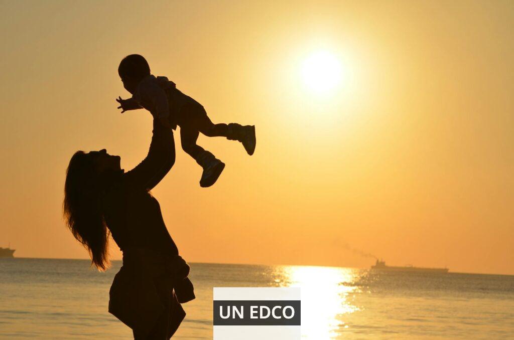 Silhouette Photo of a Mother Carrying Her Baby at Beach during Golden Hour