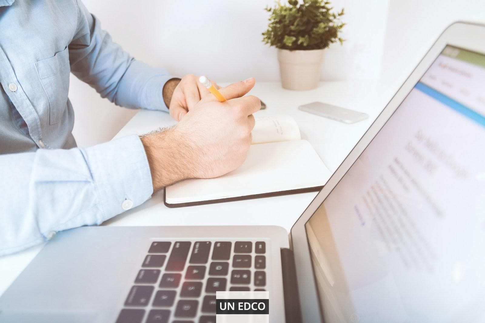 person writing on white notebook